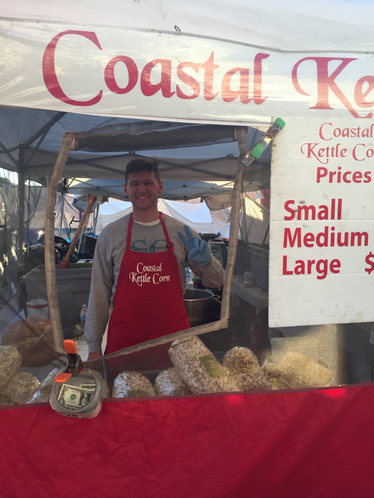 The Coastal Kettle Corn booth with the price list at a festival